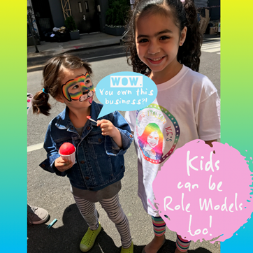 child-eating-italian-ice-and-looking-up-to-kidpreneur-indias-italian-business-owner-and-role-model-at-childrens-museum-of-the-arts-block-party-rainbow-dog-face-paint-kids-can-be-role-models-too