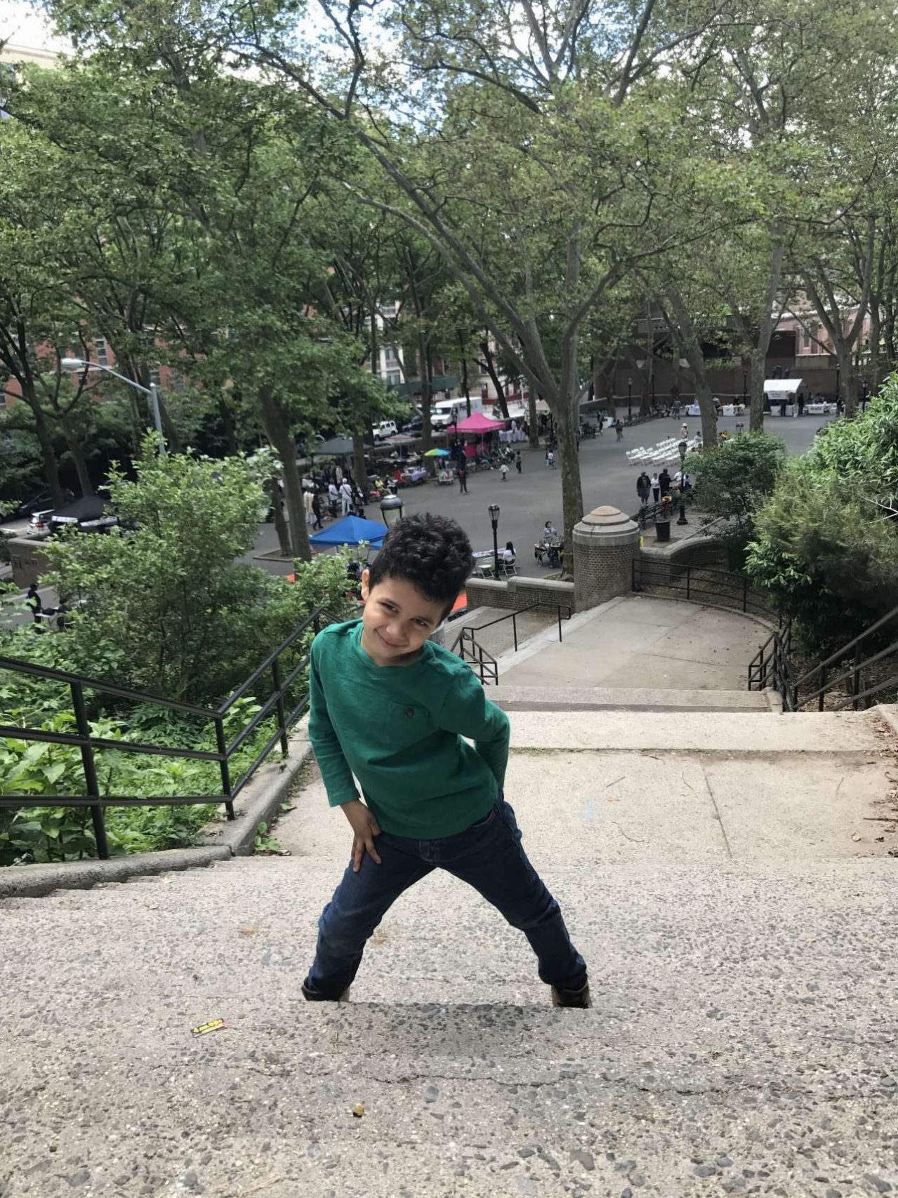 little boy posing standing on stairs in jackie robinson park above festival